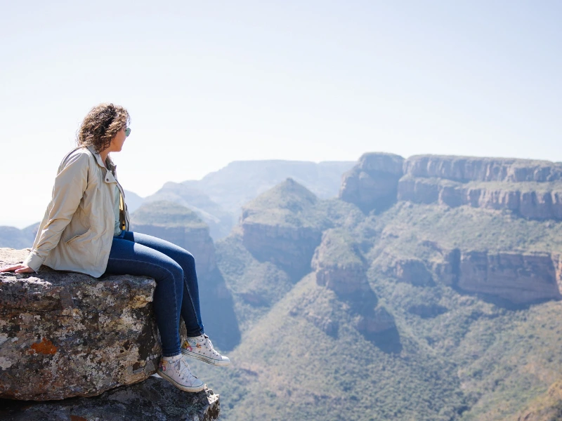 Frau sitzt auf der Klippe in Südafrika