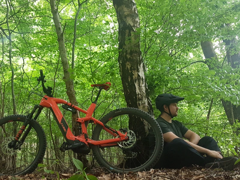 Mann mit Fahrrad im Wald