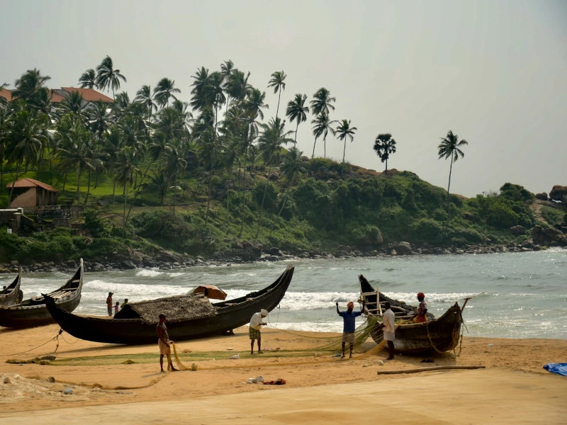 Fischerboote an einem tropischen Strand mit Palmen in Indien.