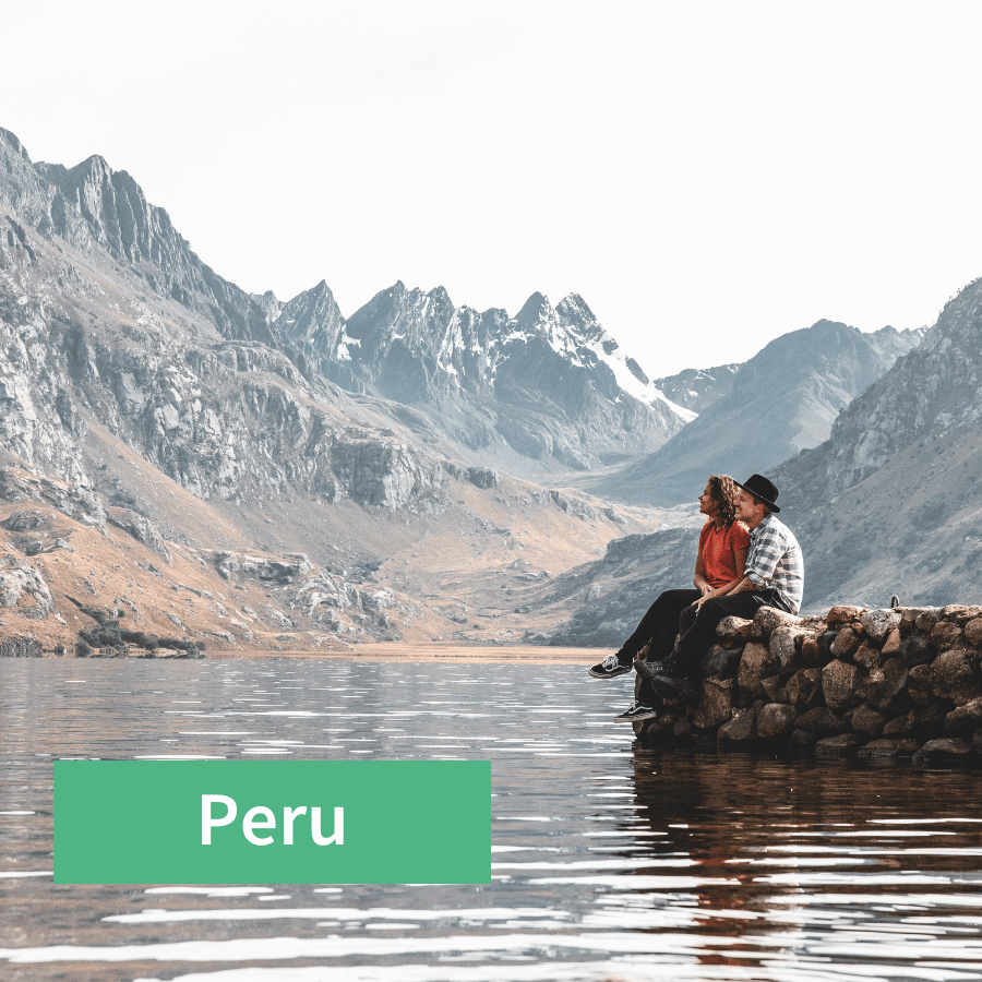 Pärchen sitzt an einem See in Peru zwischen Bergen