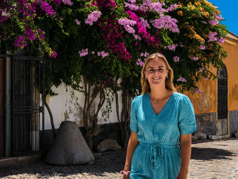 Frau steht in Italien für Haus mit Blütenranken