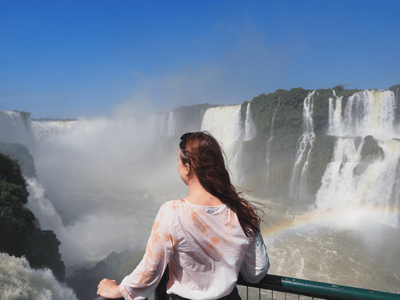 erleberin Alena steht vor den Iguaçu Wasserfällen in Brasilien
