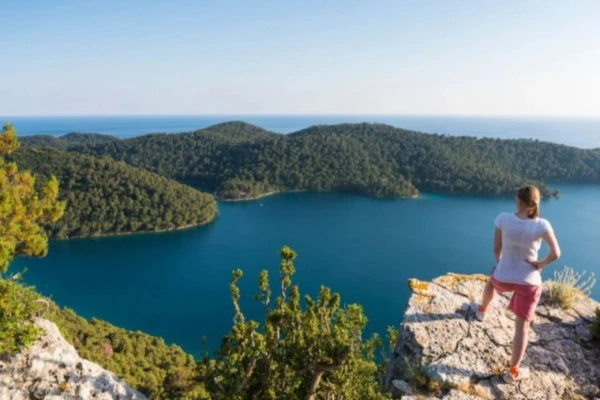 Kroatien Mljet Reisende auf einem Felsen an einer Bucht umgeben von Natur