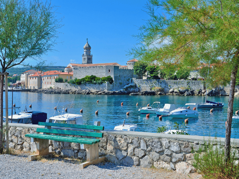Hafen von Krk mit klasklarem Wasser und kleinen Booten, die vor Anker liegen