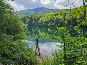 Mann in der Natur am Wasser stehend