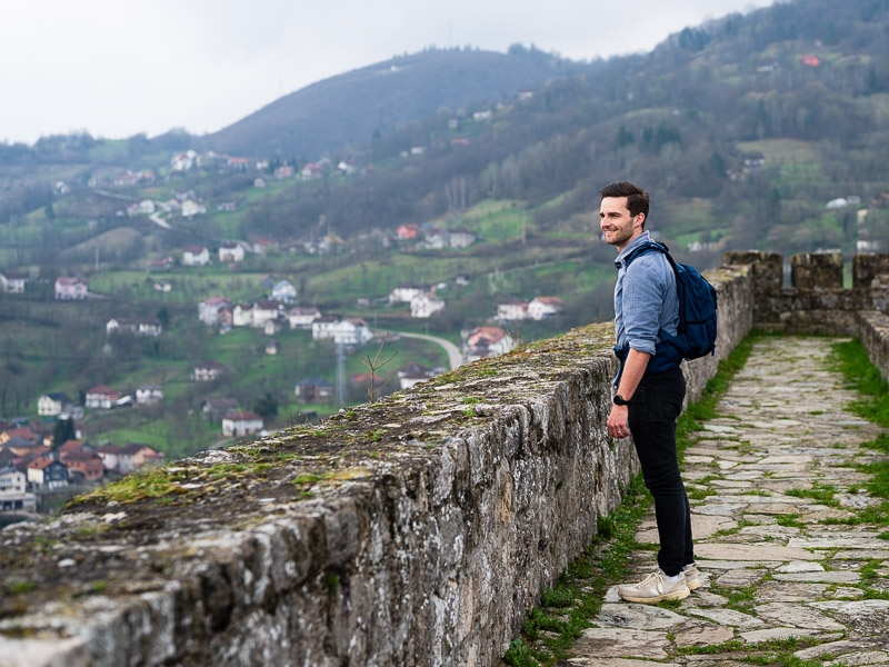 Mann steht auf einem steinigen Weg an einer Mauer
