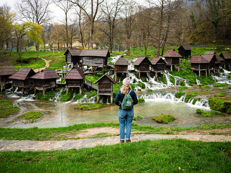 Frau schaut sich kleine Hütten im Wald an
