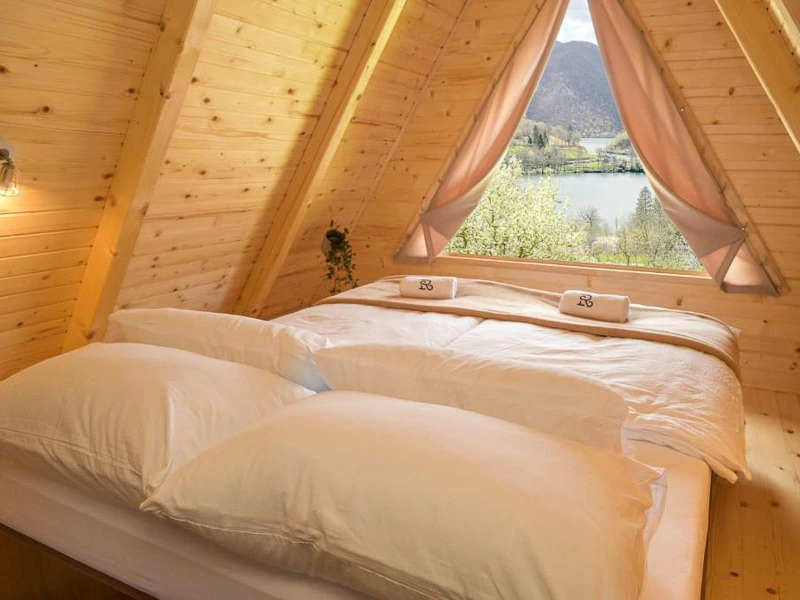 Doppelbett im Bungalow mit Blick auf den See