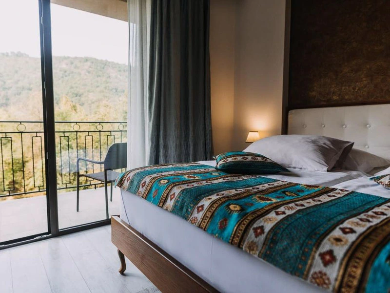 Doppelbett mit Blick auf die Terasse und die Berge