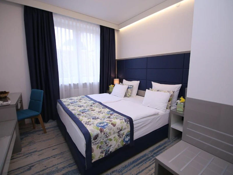 Zimmer mit Doppelbett und Stuhl