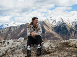 Frau sitzt in den Bergen in Lukomir