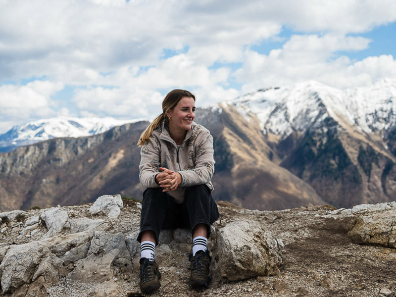 Frau sitzt in den Bergen in Lukomir
