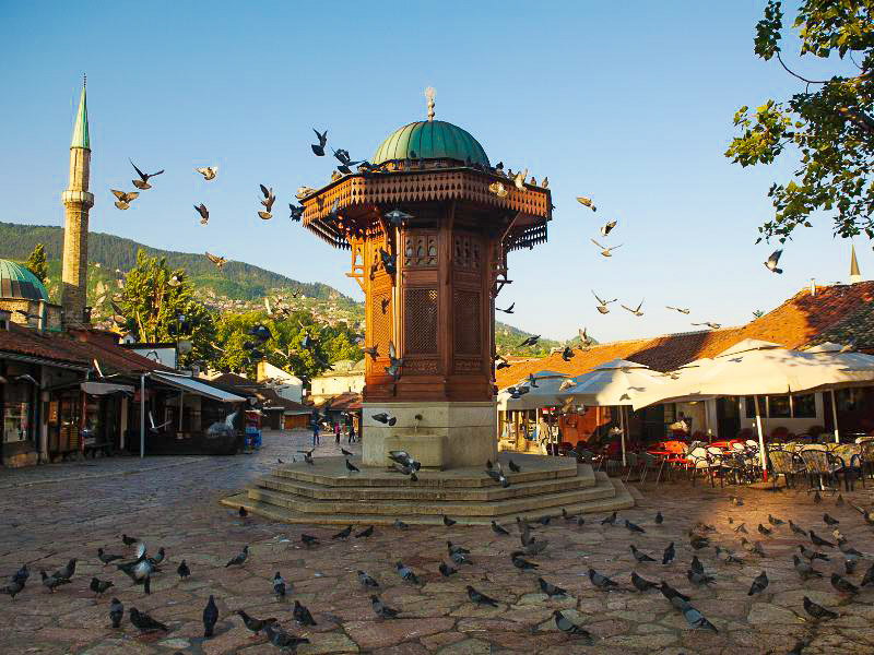 Platz mit Vögeln und Turm in der Mitte