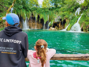 Kinder vor Wasserfall in Plitvice in Kroatien