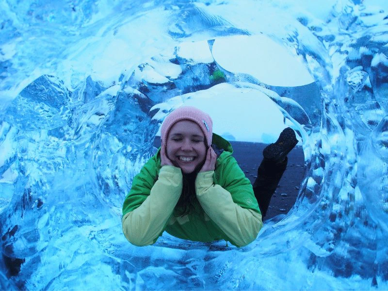 Frau liegt in einer Eishöhle