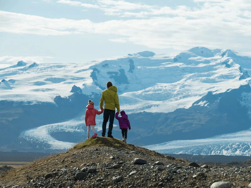 Familie auf einem Berg Aussichtspunkt vor einem Gletscher in Island