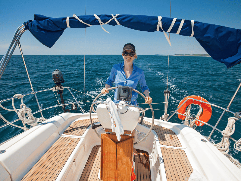 Frau navigiert ein Segelboot in Griechenland