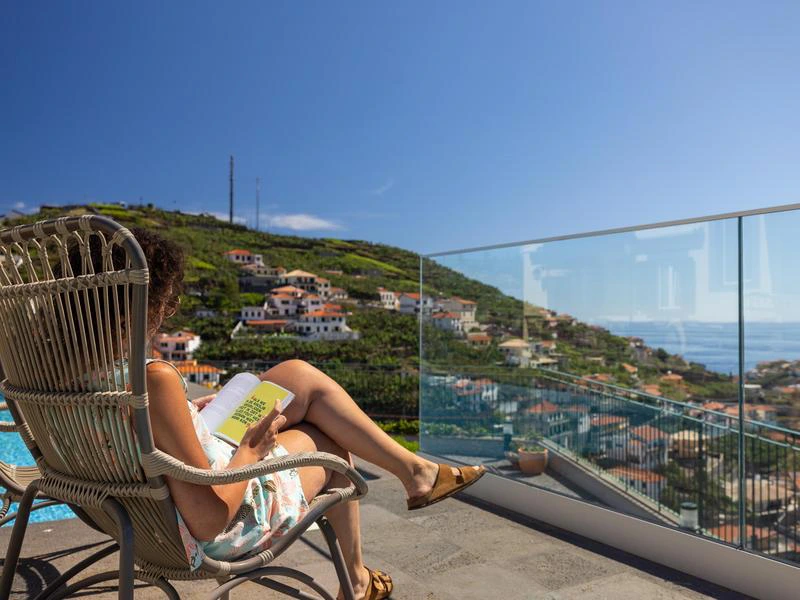 Frau im Liegestuhl mit Blick auf das Meer auf Madeira
