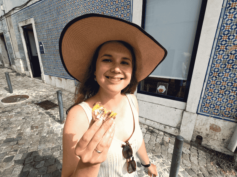 Touristin probiert die bekannten Blätterteigtörtchen Pastel de Nata