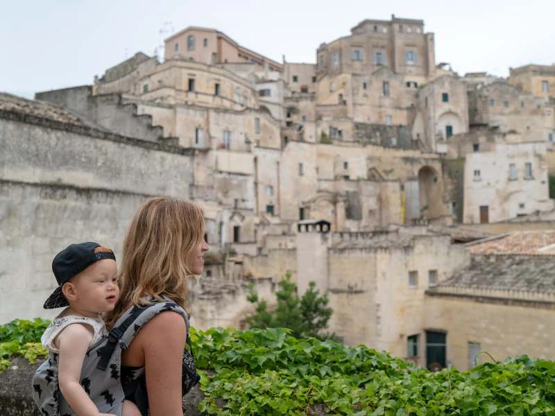 Mutter mit Sohn auf dem Rücken in Matera in Italien