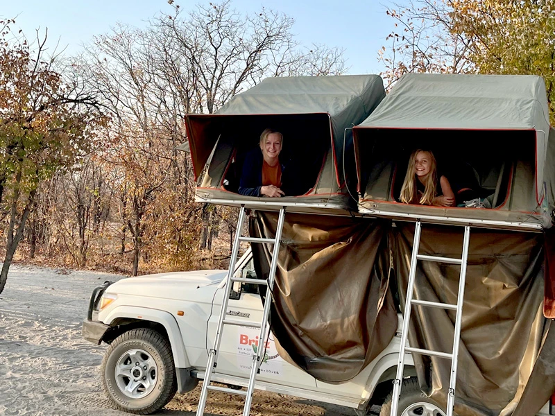 Mutter mit Tochter schauen aus dem Dachzelt in Namibia