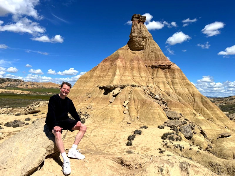 Reisender sitzt auf einem Felsen in den Bardenas Reales in Spanien.