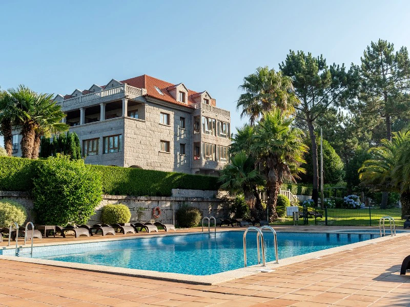 Türkisfarbener Pool mit modernen Liegen in Pontevedra