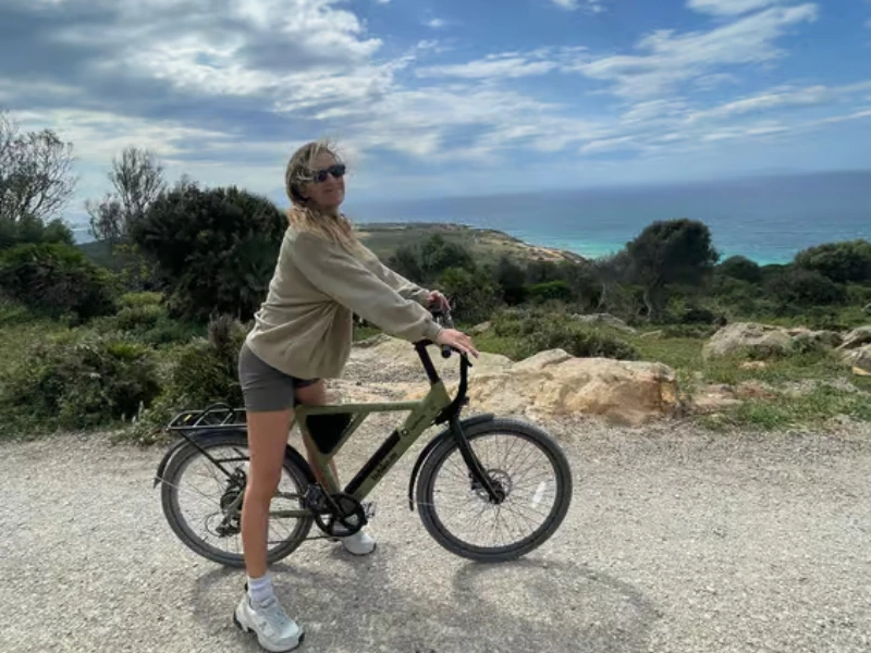 Frau auf dem Fahrrad an der Küste von Tarifa, Spanien