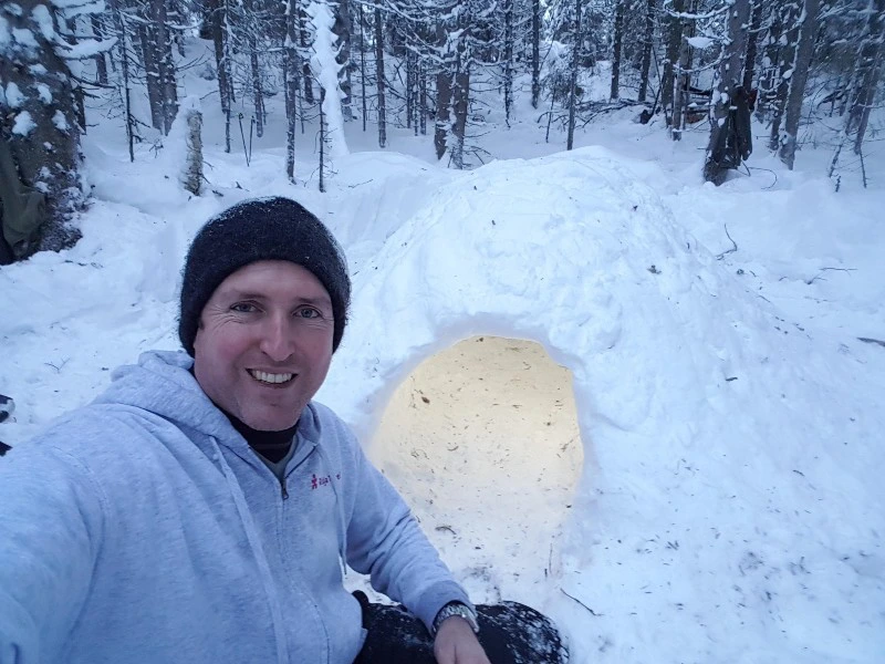 Reisender beim Bau eines Iglus in Lappland