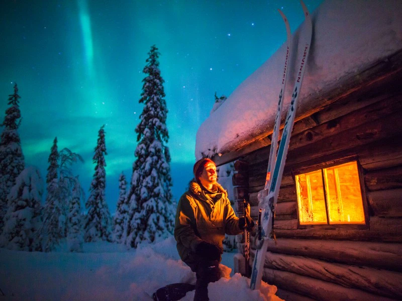 Blick auf Nordlichter und Hütte in Pyhä