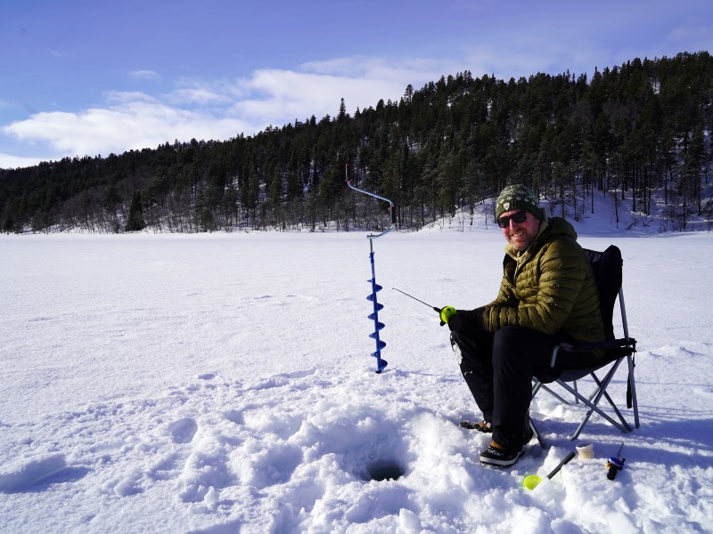 Reisender beim Eisfischen in Ukkohalla, Finnland