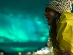 Frau blickt begeistert auf die Polarlichter