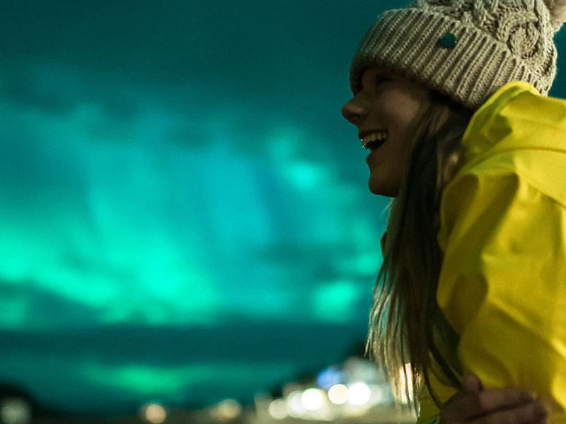 Frau blickt begeistert auf die Polarlichter
