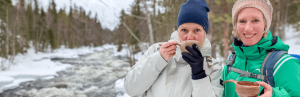 Frauen trinken Getränk im Schnee
