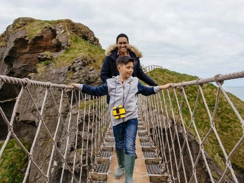 Personen laufen über die Hängebrücke