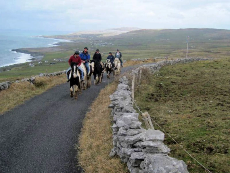 Reisende reiten entlang der Küste mit dem dem Pferd