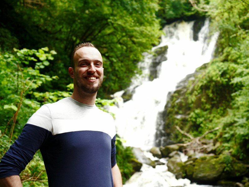 Reisender vor Wasserfall im Nationalpark Torc bei Kilarney in Irland