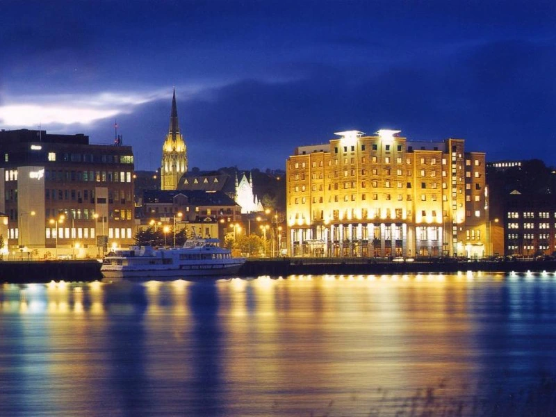 Hotel in Derry bei Nacht vom Fluss aus.