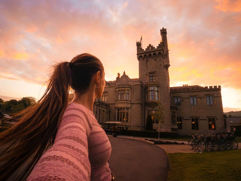 Reisende vor dem Schlosshotel bei Sonnenuntergang.