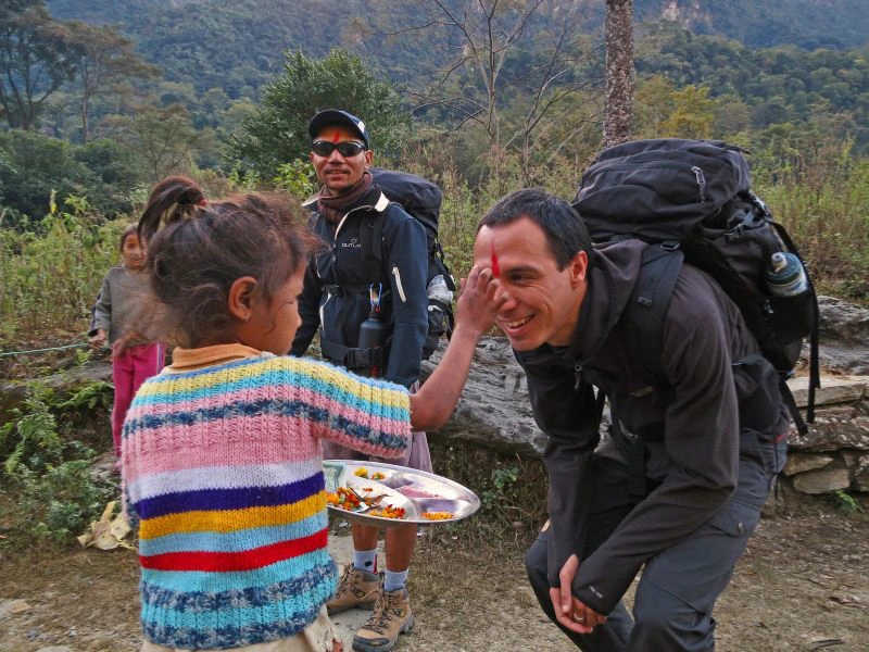 Kind in Annapurna segnet einen Reisenden