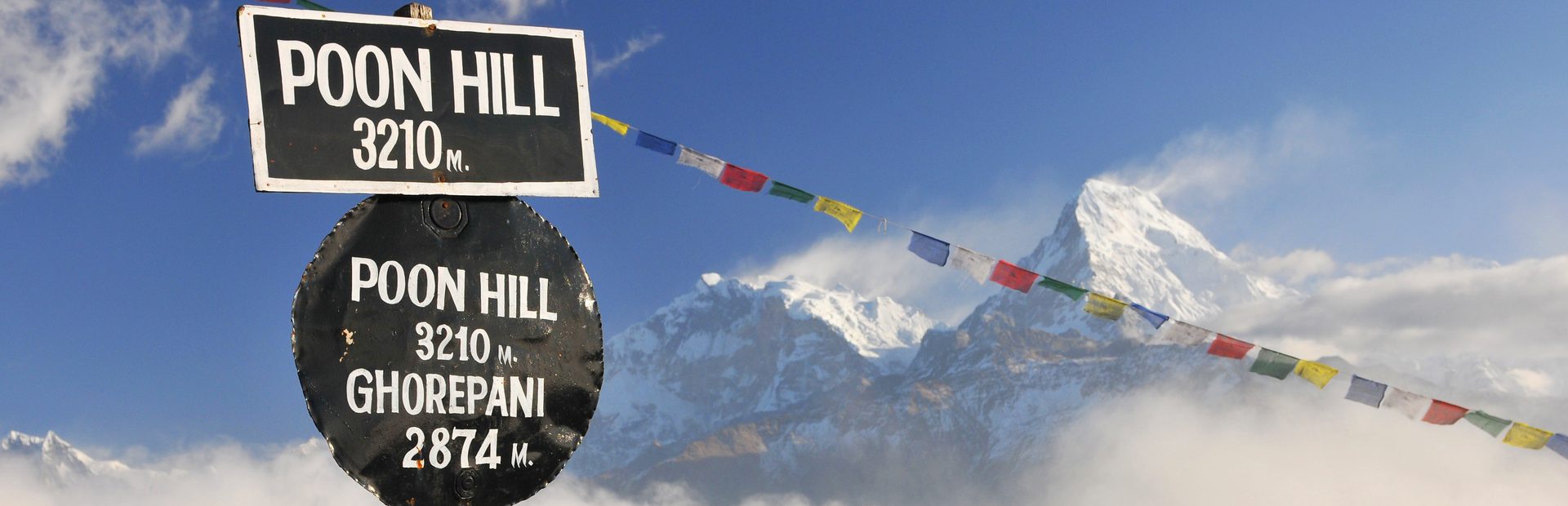 Schild mit Gebetsflaggen am Poon Hill Gipfel in Nepal