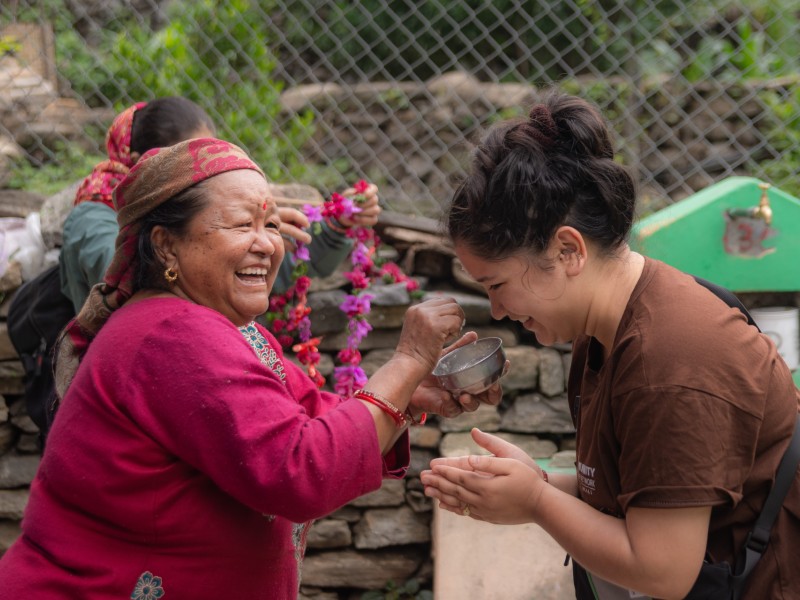 Tourist wird von einer Einheimischen im Homestay in Nepal empfangen