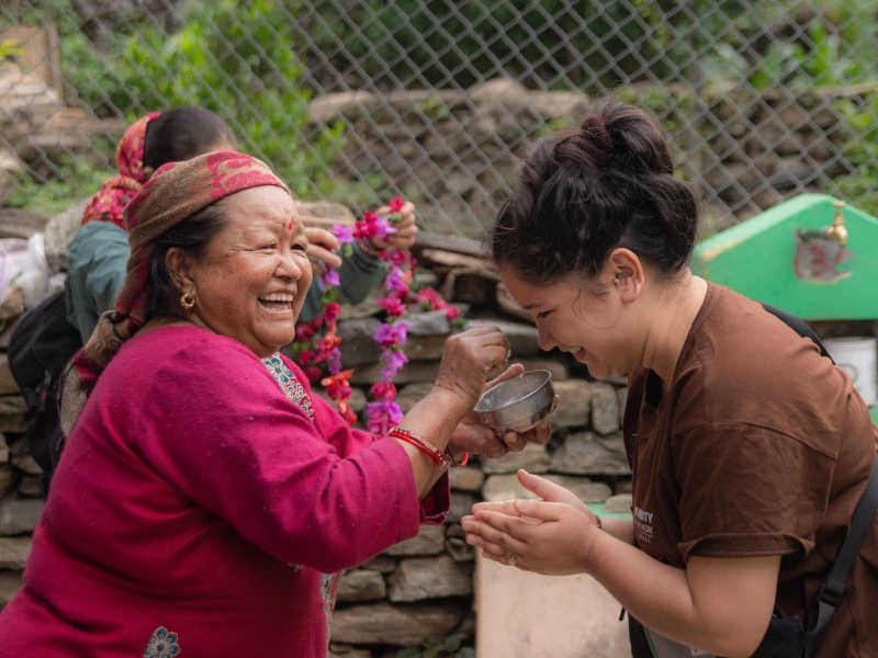 Tourist wird von einer Einheimischen im Homestay in Nepal empfangen