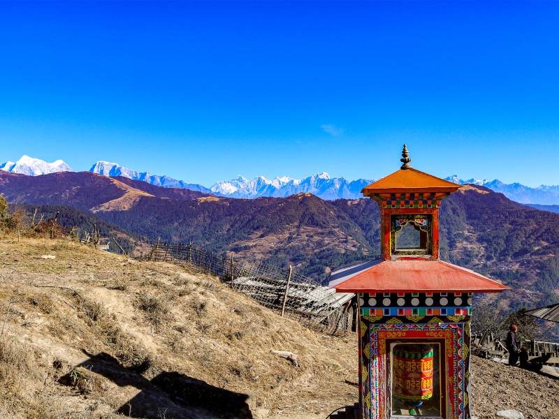 Traditioneller buddhistischer Gebetsmühlen-Schrein vor einer Bergkulisse in Nepal