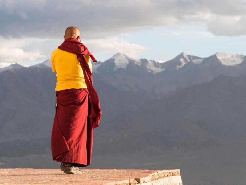 Mönch blickt in die Ferne auf das Himalaya Gebirge in Lhasa in Tibet