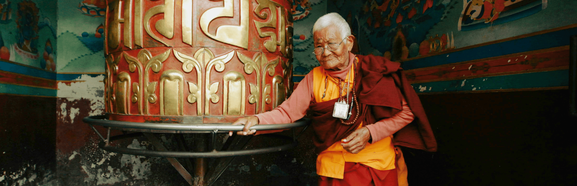 Mönch an Gebetsmühle, Tibet