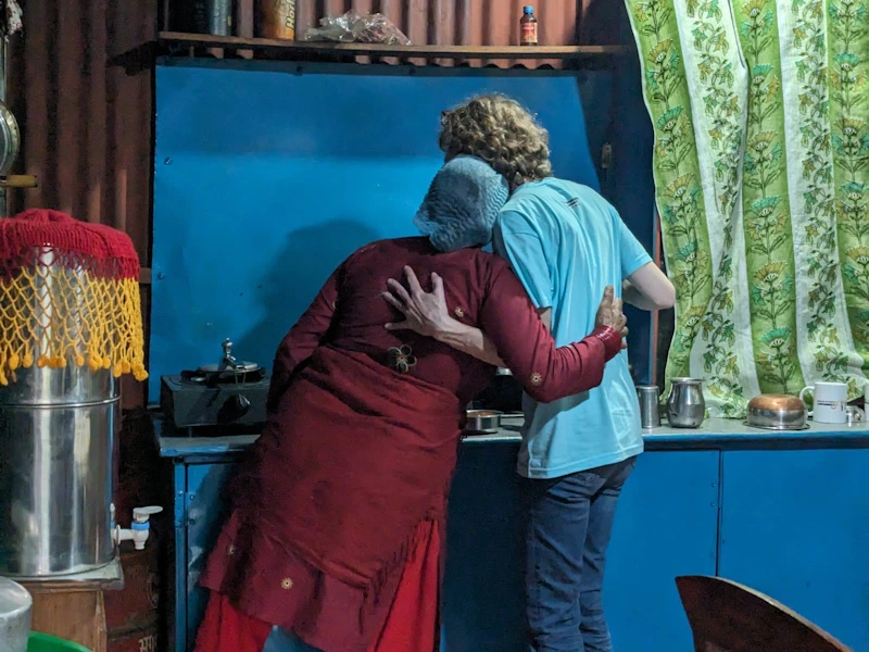 Touristin mit Gastgeberin beim Kochen im Homestay