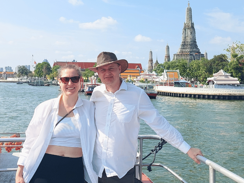 Touristen auf dem Chao Phraya vor dem Wat Arun in Bangkok