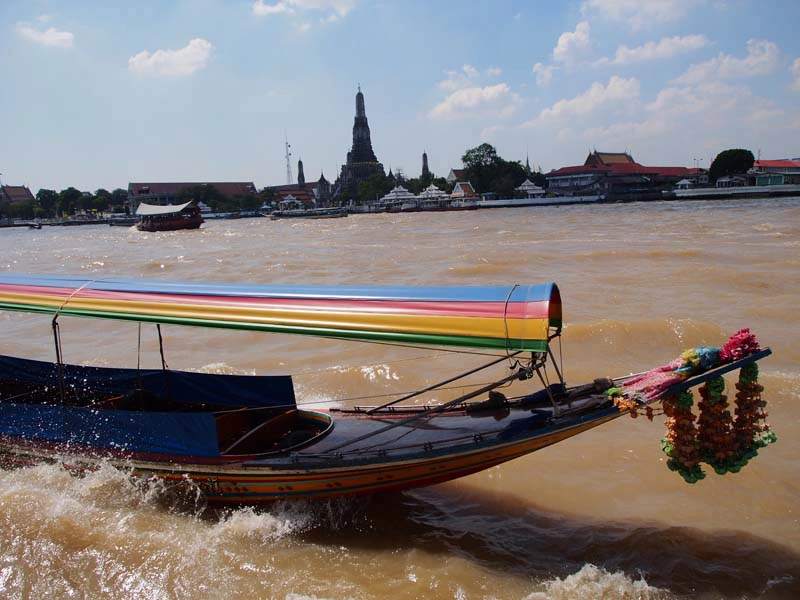 Longtailboot in Bangkok mit Aussicht auf Tempel