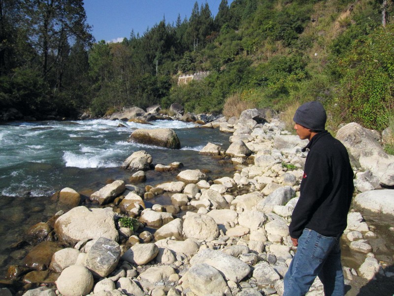 Reisender an einen Fluss auf dem Weg nach Mongar, Bhutan